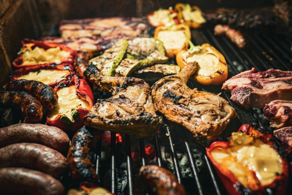 A mouthwatering assortment of meats and vegetables grilling on a barbecue, showcasing a rich and delicious feast.