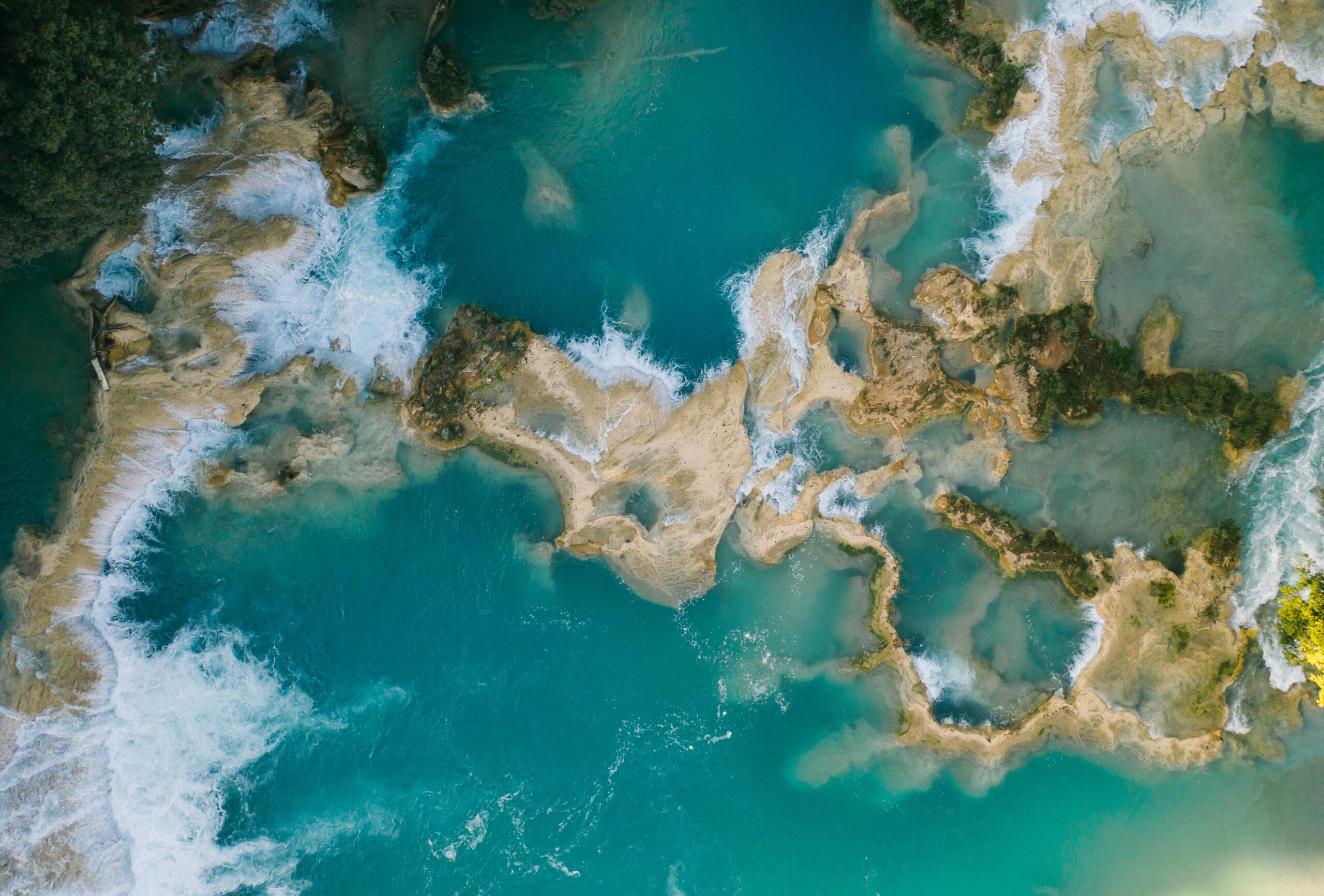 Stunning aerial capture of turquoise waterfalls in Chiapas, showcasing natural beauty and vibrant waters.